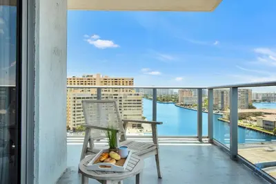 a balcony with a chair and a view of the water at Very Chic - Bay View & Balcony - Amazing Pools- Gym in Hollywood
