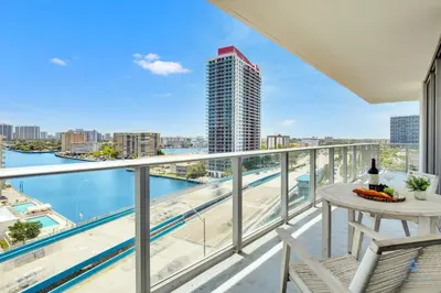 a balcony with a table and chairs and a view of the water at Very Chic - Bay View & Balcony - Amazing Pools- Gym in Hollywood