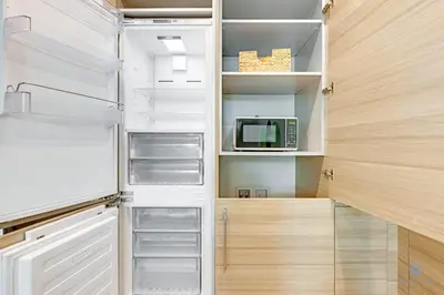 a kitchen with an empty refrigerator and a microwave at Modern Luxury Retreat: Rooftop Pool Ocean Views in Hollywood