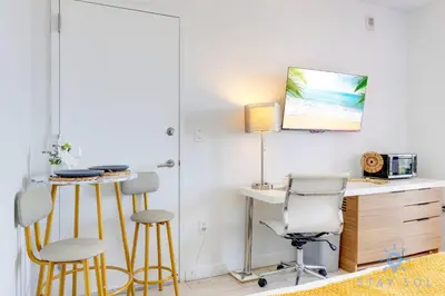 a room with a desk and two chairs and a table at Modern Condo - Amazing Pool - Gym - Balcony in Hallandale Beach
