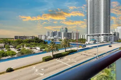 a highway in front of a city with tall buildings at Modern Condo - Amazing Pool - Gym - Balcony in Hallandale Beach