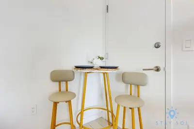 a table and two stools in a room at Modern Condo - Amazing Pool - Gym - Balcony in Hallandale Beach