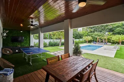 a patio with a ping pong table and a pool at Modern New Construction Villa in Hollywood