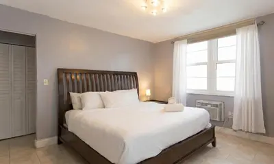 a bedroom with a large white bed and a window at South Beach One Bedroom Condo with Parking Spot in Miami Beach