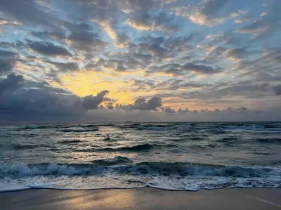 a sunset on the beach with the ocean at South Beach One Bedroom Condo with Parking Spot in Miami Beach