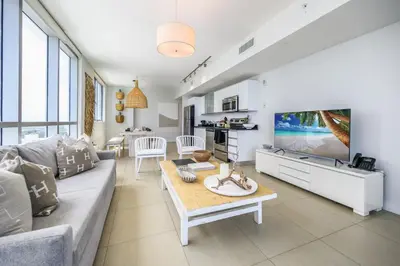 a living room with a couch and a tv at MonteCarlo Miami Beach in Miami Beach