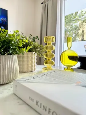 a book on a table with two yellow glass bottles at Modern / Central / Free Pkg in Miami Beach