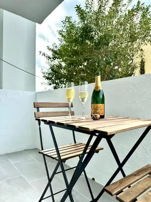 a wooden table with two wine glasses and a bottle at Modern / Central / Free Pkg in Miami Beach