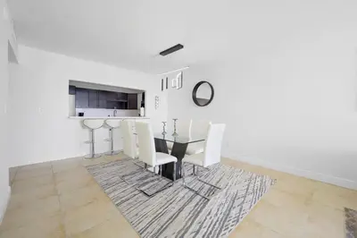 a dining room with a glass table and white chairs at Spacious apartment in Ocean Reserv of 2br - 2bth great price in Sunny Isles Beach
