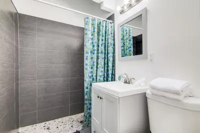 a white bathroom with a sink and a shower at Cozy South Beach 1BR Apt Near Beach & Ocean Drive in Miami Beach