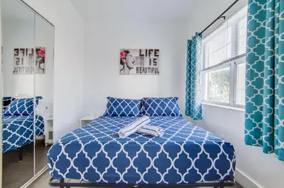 a bedroom with a blue bed and a mirror at Chic Large Studio Apt Near Ocean Drive South Beach in Miami Beach