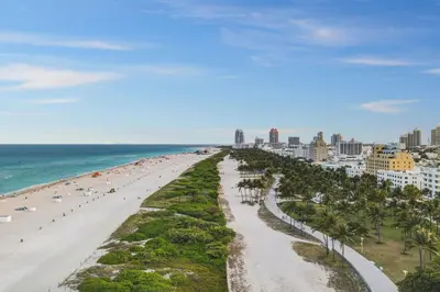 a view of a beach with palm trees and the ocean at Chic Large Studio Apt Near Ocean Drive South Beach in Miami Beach
