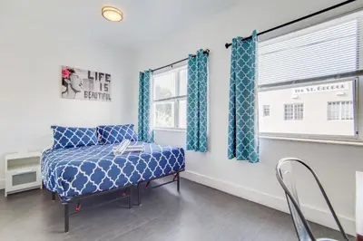 a room with a blue bed and a window at Chic Large Studio Apt Near Ocean Drive South Beach in Miami Beach