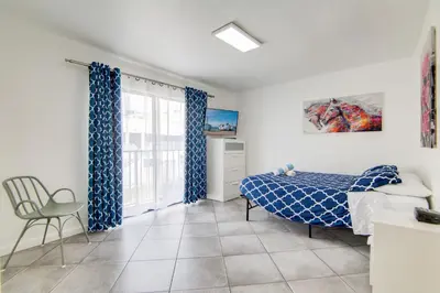 a bedroom with a bed and a chair and a window at 2B/2B, Free Parking, South Beach, 1 Block 2 Beach in Miami Beach