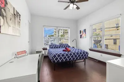 a living room with a table and a ceiling fan at South Beach 2BR with Private Balcony, Walk to Beach in Miami Beach