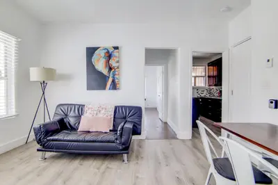 a living room with a leather couch and a table at 2 B/R- Heart of South Beach, Near Ocean Dr & Beach in Miami Beach