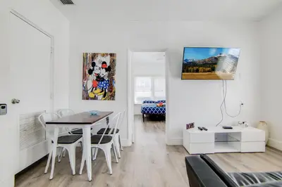 a white living room with a table and a dining room at 2 B/R- Heart of South Beach, Near Ocean Dr & Beach in Miami Beach