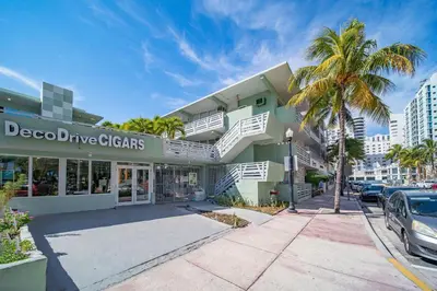 a building with a car parked in front of it at Balcony Chic Apt, w/2 Queenbeds, on Ocean Dr Beach in Miami Beach