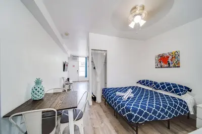 a bedroom with a bed and a table and chairs at Ocean Drive Comfy apt, w/2 Queen Beds by the Beach in Miami Beach