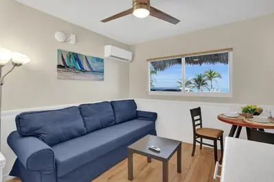 a living room with a blue couch and a table at Beach Condo 2BR & Efficiency Combo on Hollywood Beach in Hollywood