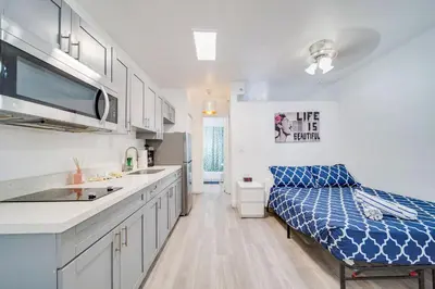 a kitchen with white cabinets and a blue bed in it at Beachy 1 b/r, w/2 Queen Beds, On Ocean Drive Beach in Miami Beach