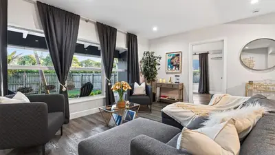 a living room with two couches and a large window at Hot Tub Firepit Deck 10mins to Beach Near Las Olas Middle Terrace Cottage by AvantStay in Fort Lauderdale