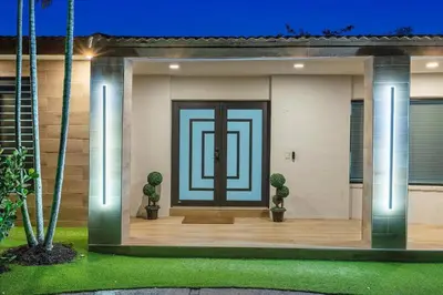 a front door of a house with two cactus at VillaKOBO Heated pool Spa Golf Tennis crocodile in Miami