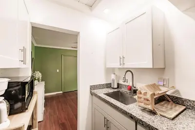 a kitchen with white cabinets and a sink at Uhost AI - Updated 1B1B Hideaway - Sleeps 3 in Hollywood