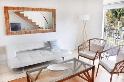 a living room with a white couch and a mirror at Suites at Coral Resorts in Miami