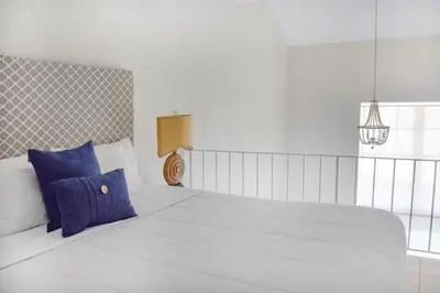 a bedroom with a large white bed with blue pillows at Suites at Coral Resorts in Miami