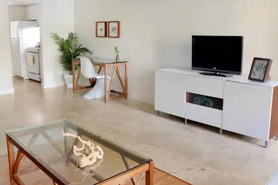 a living room with a tv and a glass table at Suites at Coral Resorts in Miami