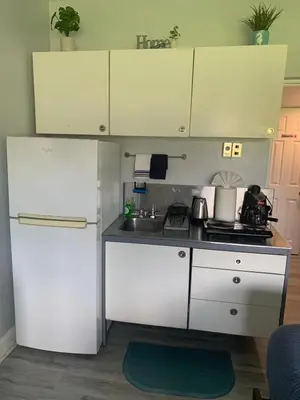 a small kitchen with white cabinets and a stove at Walk to the beach, Studio, with Pool and FREE Parking in Hallandale Beach