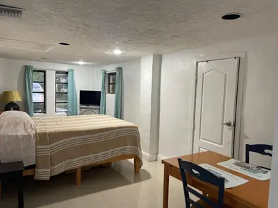 a bedroom with a bed and a table and a desk at CHEERFUL PRIVATE ROOM 2 MILES AWAY FROM SUNNY ISLES BEACH in North Miami Beach
