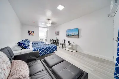 a living room with a couch and a bed at Deco Beachside Apt, w/2 Queen Beds, Washer/Dryer in Miami Beach