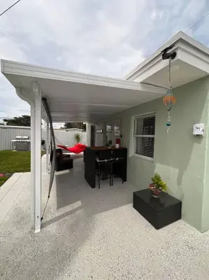 a patio with a white pergola and a table at Casita Cafe in Miami