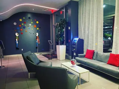 a living room with two couches and a wall with a ball wall at Sunny Mornings & 2 Full Beds, BeachWalk Studio in Hallandale Beach
