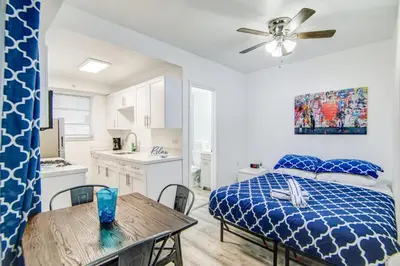a bedroom with a bed and a table and a kitchen at Balcony Deco Apt, w/2 QueenBeds, on Ocean Dr Beach in Miami Beach