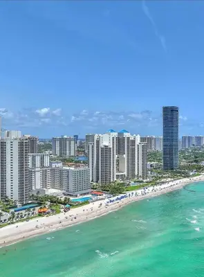 an aerial view of a beach with buildings and the ocean at Miami Sunny Isles Beach Ocean Front Resort Condo with balcony Pool, Beach,Gym,Valet Parking in Sunny Isles Beach