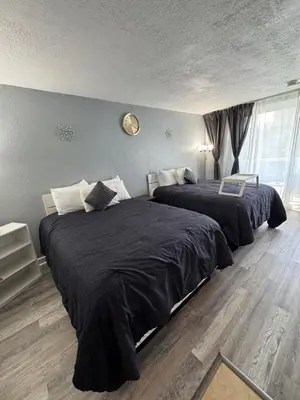 a bedroom with two beds with black sheets and a window at Miami Sunny Isles Beach Ocean Front Resort Condo with balcony Pool, Beach,Gym,Valet Parking in Sunny Isles Beach
