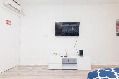 a living room with a tv on a wall at Ocean Drive Deco Apt w/2 Queen Beds, Steps 2 Beach in Miami Beach