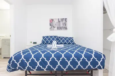 a bed in a room with a blue comforter at Ocean Drive Deco Apt w/2 Queen Beds, Steps 2 Beach in Miami Beach