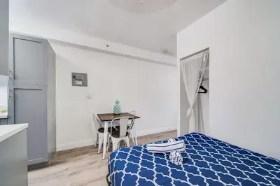 a bedroom with a blue bed and a table at Steps 2 Beach, Ocean Drive Deco Apt w/2 Queen Beds in Miami Beach