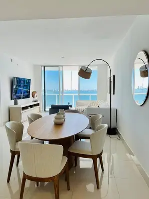 a living room with a dining room table and chairs at Soñada vista al agua 3/3 in Miami