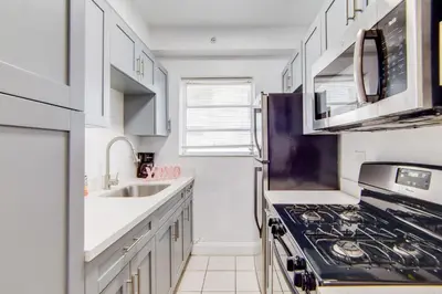a kitchen with white cabinets and a stove top oven at Steps 2 Beach, Prime Ocean Dr Condo w/2 Queen Beds in Miami Beach