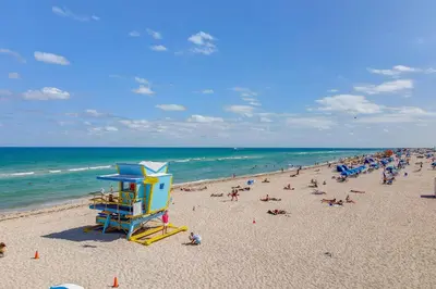 a beach with a bunch of people on it at Stylish Ocean Dr Apt w/ 2 Queen Beds, Across Beach in Miami Beach