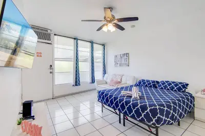 a living room with a bed and a ceiling fan at Sunny Ocean Dr Condo, w/2 Queen Beds, South Beach in Miami Beach