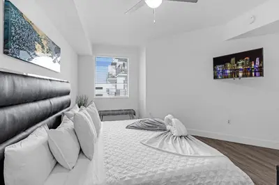 a white bedroom with a large bed with pillows at Tranquil 1 Bed Escape in Doral With Free Parking in Hialeah Gardens