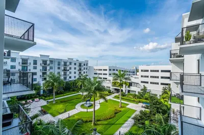 an apartment complex with a park and palm trees at Tranquil 1 Bed Escape in Doral With Free Parking in Hialeah Gardens