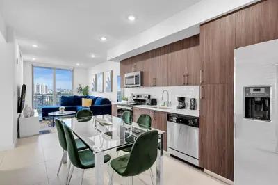 a kitchen with a glass table and green chairs at Charming 3-Bed Mins from Brickell With Free Parking in Miami