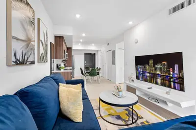 a living room with a blue couch and a tv at Charming 3-Bed Mins from Brickell With Free Parking in Miami
